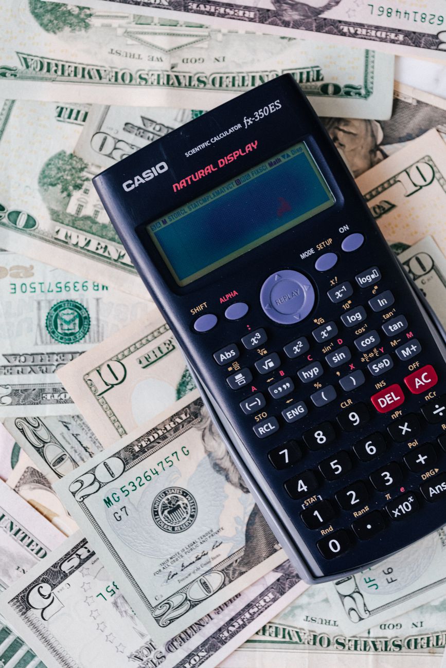 Calculator on top of US dollar bills, illustrating real estate crowdlending yield calculations